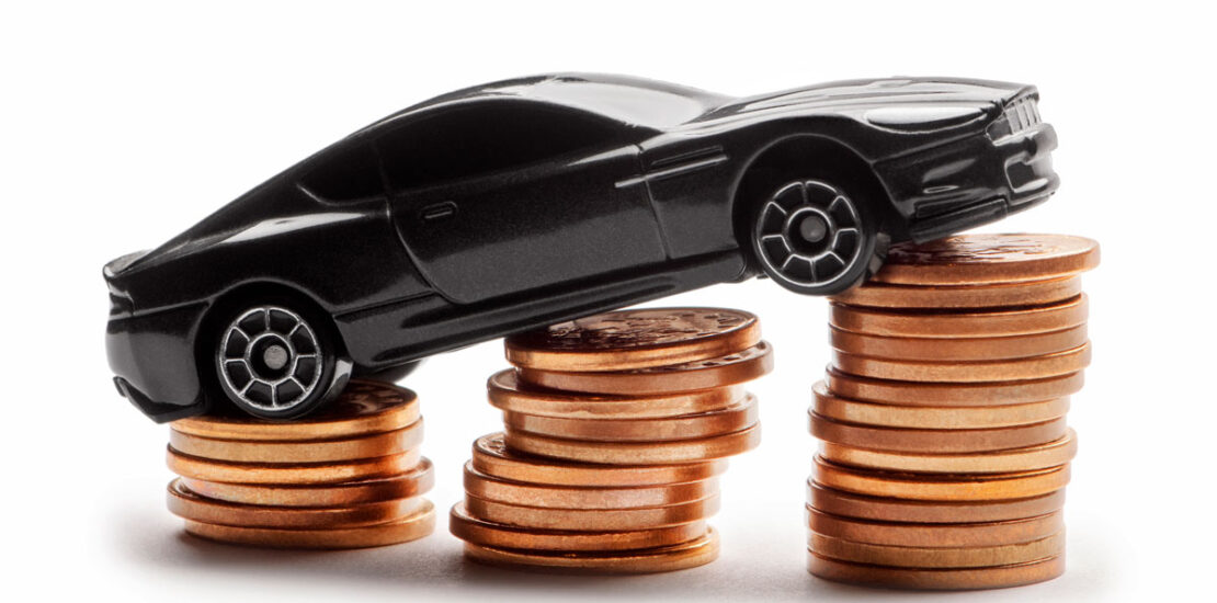 A toy car sitting on a pile of coins, representing how insurance premiums go up after a DUI.