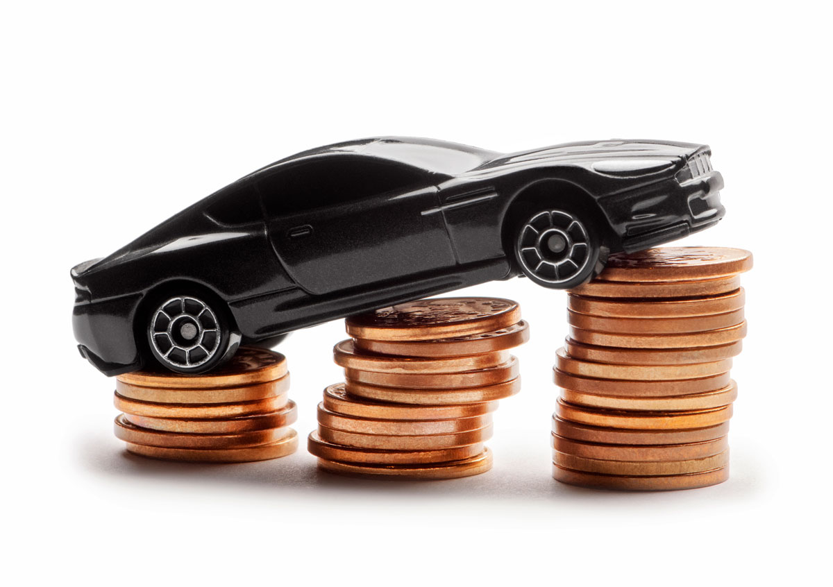 A toy car sitting on a pile of coins, representing how insurance premiums go up after a DUI.
