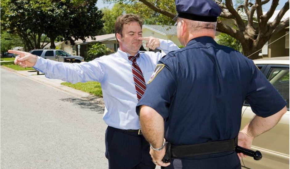 Un homme passant un test de coordination devant un policier pour vérifier l'alcool au volant.